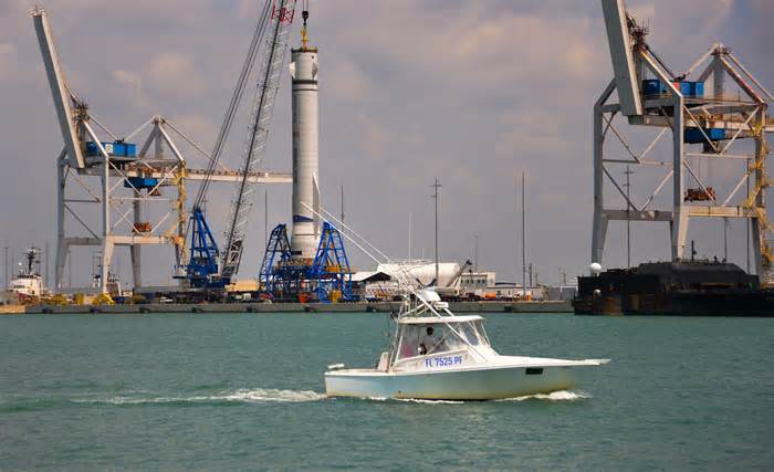 Mockup of Blue Origin's New Glenn stands next to SpaceX's Falcon 9 at Port Canaveral